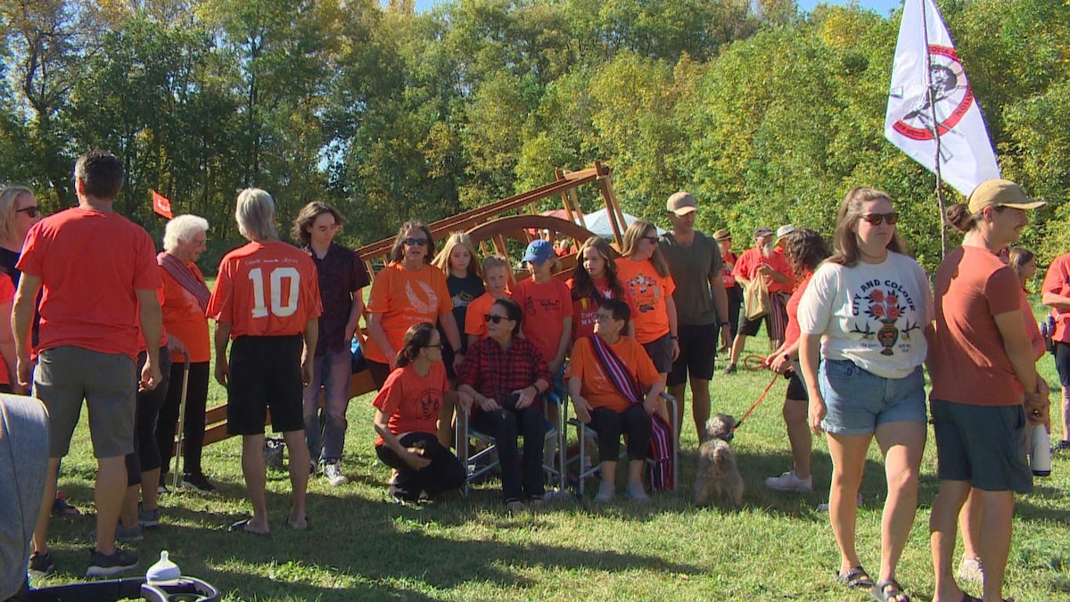 Des personnes, dont plusieurs sont habillées en orange dans un espace vert, le 28 septembre 2024 à Saint-Adolphe au Manitoba.