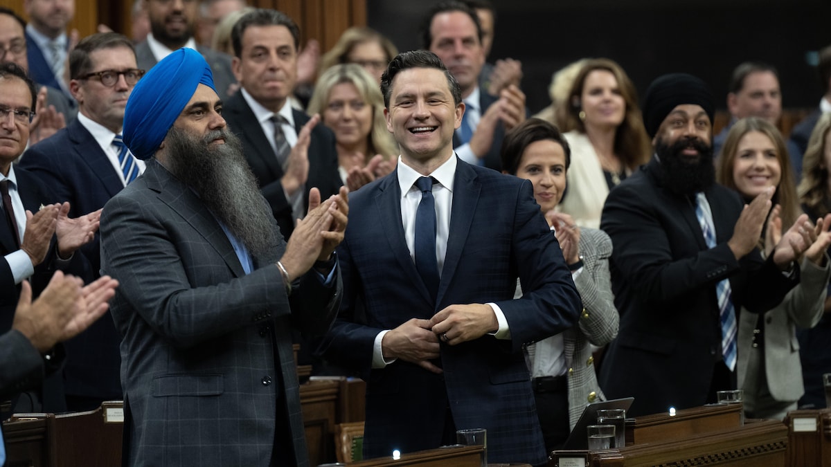 Pierre Poilievre, debout, est applaudi par ses députés.