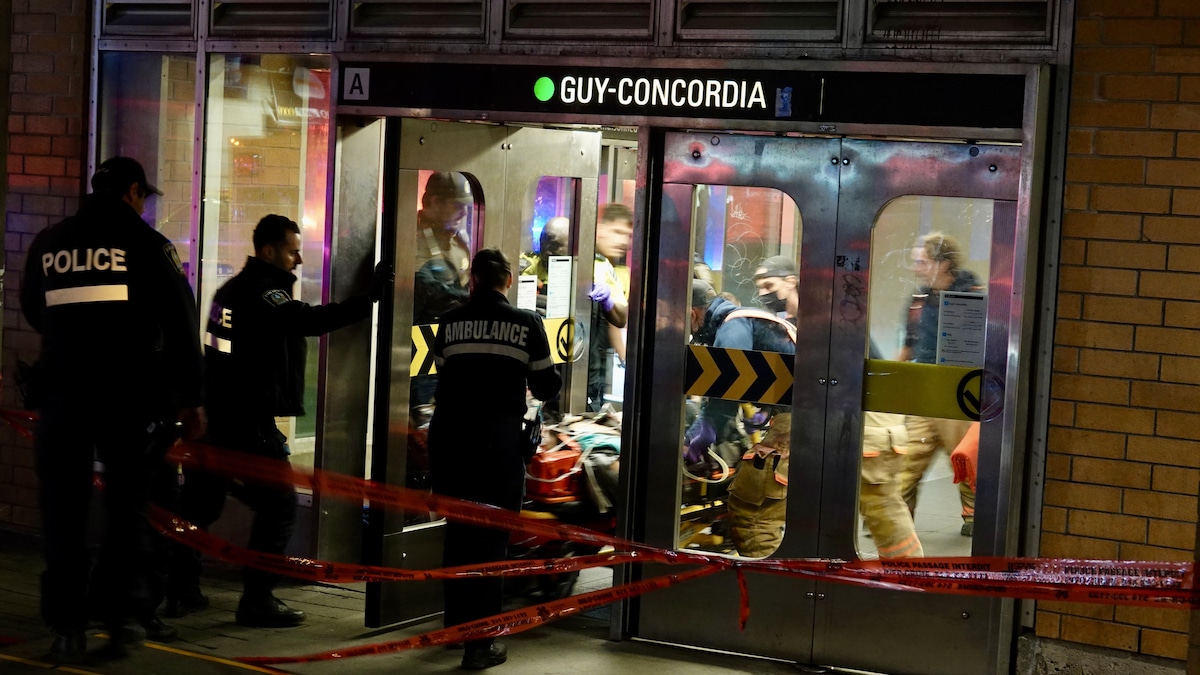 Des policiers et des ambulanciers transportent un homme sur une civière dans une station de métro.