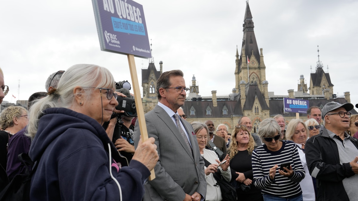 Le chef du Bloc, Yves-François Blanchet, se tient parmi la foule avant de s'adresser à un groupe sur la colline du Parlement au sujet de l'amélioration des prestations pour les aînés, le mardi 1er octobre 2024, à Ottawa.