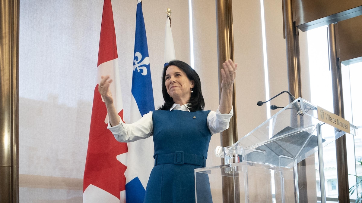 Valérie Plante levant les bras derrière un lutrin.