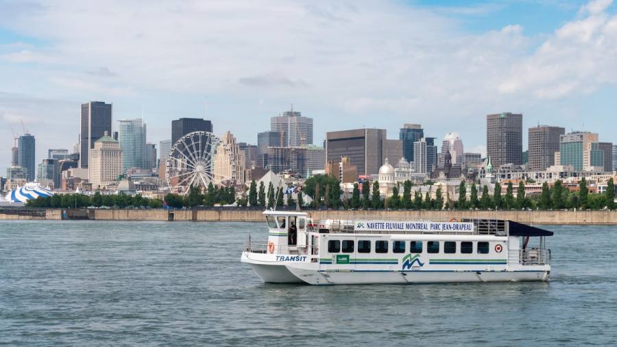 La navette sur le Saint-Laurent, le Vieux-Montréal et le centre-ville en arrière-plan.