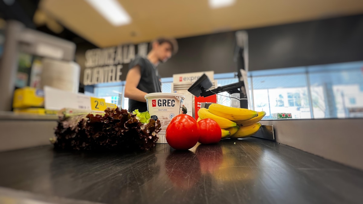 Le caissier d'une épicerie lit le code QR des produits.