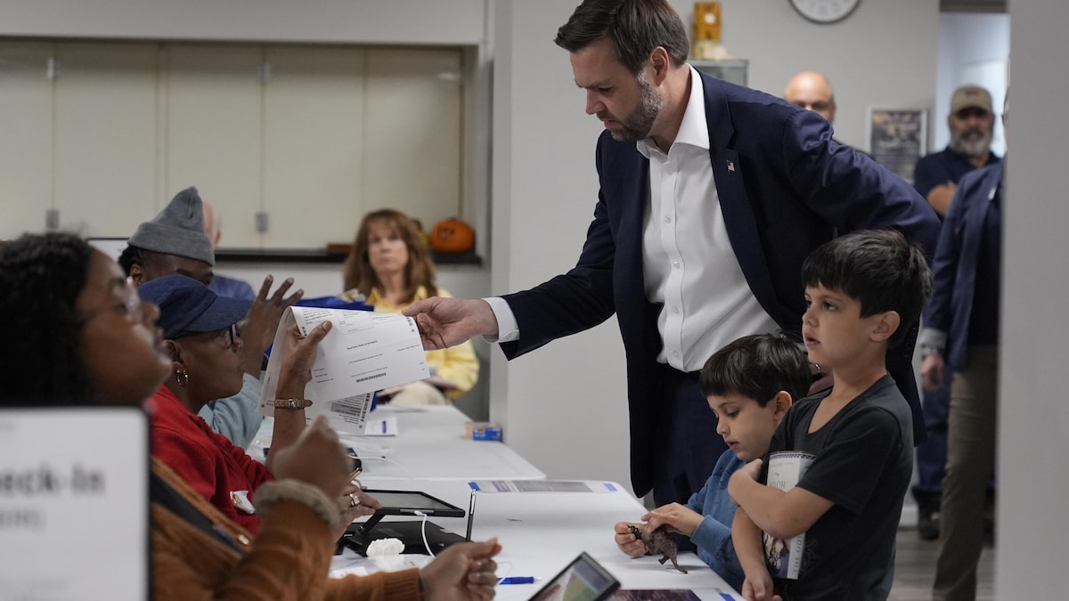 Un homme vote accompagné de ses enfants.