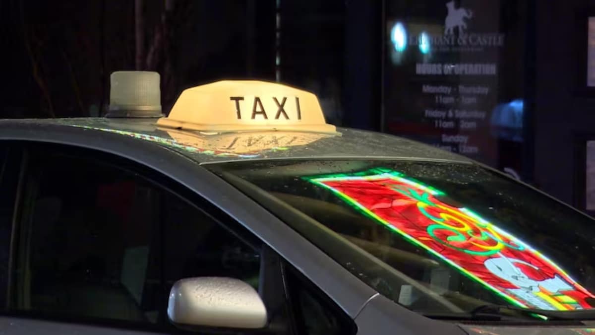 Un véhicule dont le toit porte un panneau de taxi.